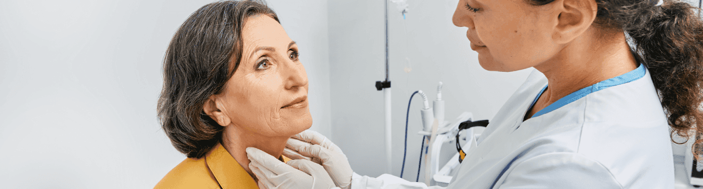 Médica tocando pescoço de mulher.